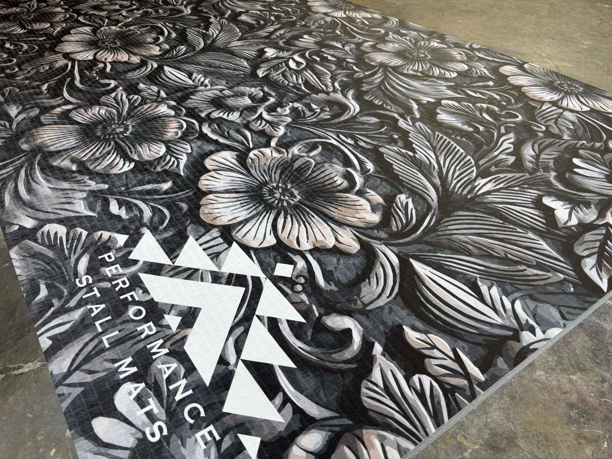 Performance Stall Mat 5 by 10 Black floral-patterned mat with a brand logo