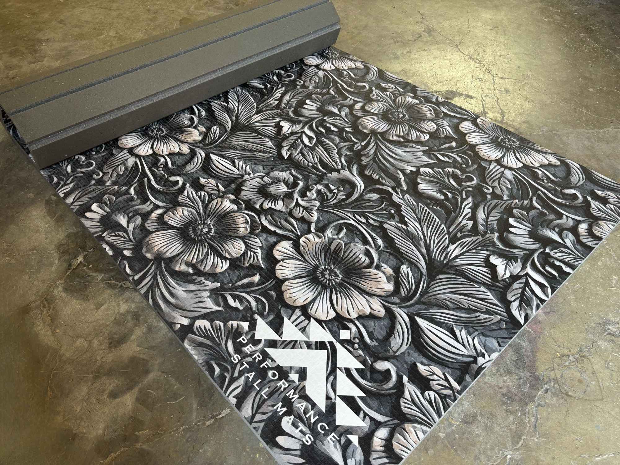 Performance Stall Mat 5 by 10 Black floral-patterned mat with a brand logo